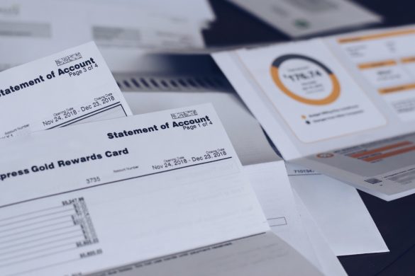 Scattered utility bills and credit card statements on a desk.